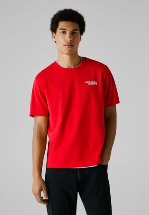 Rode katoenen t-shirt met korte mouwen en ronde hals. Bevat het "RED BULL RACING" logo in het wit op de linkerborst.