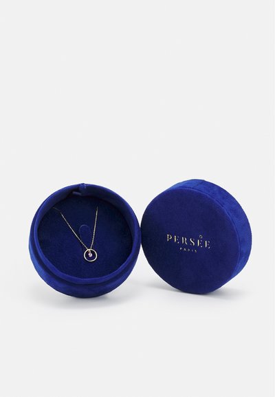 Runde, blaue Samt-Schmuckschatulle mit goldener Schrift. Enthält eine zarte goldene Halskette mit einem kreisförmigen Anhänger und einem lila Edelstein.