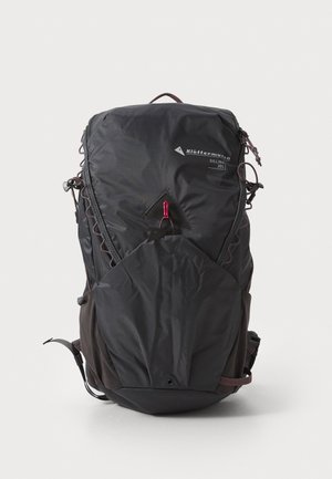 Černý nylonový batoh s elegantním designem, vybavený horním zipem, nastavitelnými popruhy a přední kapsou se výraznými diagonálními švy.