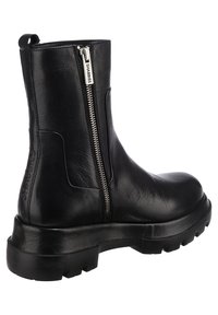 Svart läderankelboot med en sidodragkedja, rund tå, kraftig gummisula och prägling med varumärket på sidan.