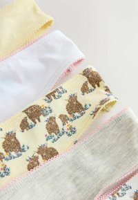 Quatre sous-vêtements pour enfants pliés dans des couleurs pastel, dont un avec un ours brun et un motif floral, bordé de dentelle rose.