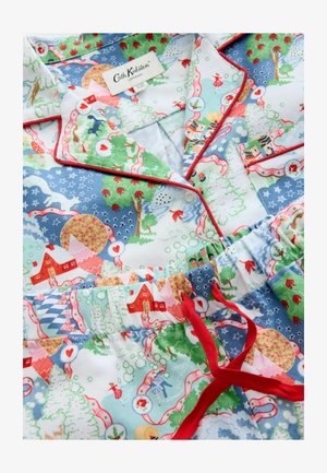 Baumwoll-Pyjama-Set mit einem bunten Feiertagsmuster, das Häuser, Bäume und fantasievolle Figuren zeigt. Rote Paspeln und ein elastischer Bund setzen Akzente.