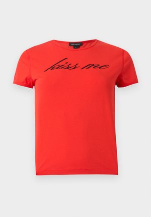 Punainen lyhythihainen Marc Jacobs -t-paita, jossa on pyöreä kaula-aukko ja musta kursiivilla oleva "kiss me" -teksti rinnassa.