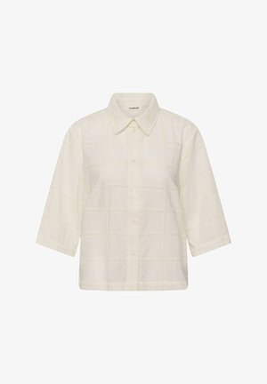 Camicia da donna color crema con bottoni davanti, maniche a tre quarti e delicato motivo a quadretti traforati, con colletto appuntito.