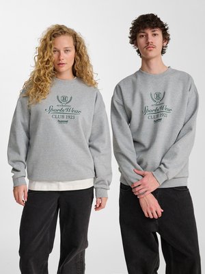 To personer iført matchende grå sweatshirts med teksten "Authentic Sports Wear Club 1923", stående side om side mod en hvid baggrund.