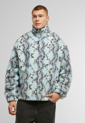 Kvartzip fleece-pullover i ljusblått med svart och grått ornmönster, med en texturerad yta och elastiska muddar.
