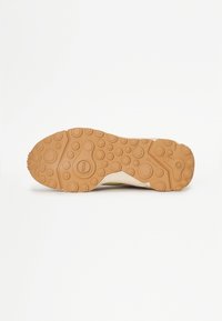 Sneaker sole with a textured, circular pattern. Rubber material in light brown, featuring a beige upper edge and embossed logo details.