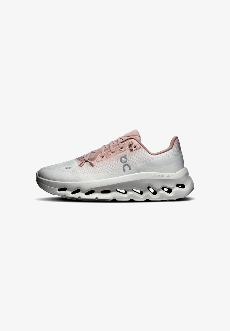 Chaussure de course rose clair et blanche avec semelle perforée et lacets, vue latérale montrant le logo de la marque et le design de l'amorti.