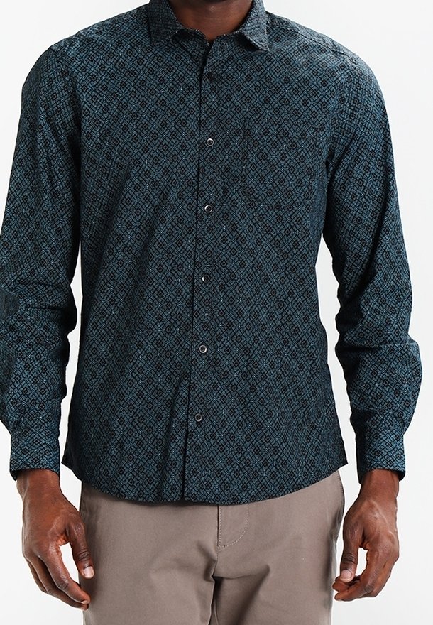 Langsleeve shirt in donkerblauwe stof met een geometrisch patroon. Kenmerkt zich door een puntkraag, knoopsluiting en een getailleerde pasvorm.