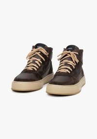 Bruine high-top sneakers van suede en leer, met beige veters, een dikke crèmekleurige zool en een logo op de tong.