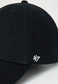 Cappello in velluto a coste nero con visiera curva, logo ricamato '47' in bianco e fori di ventilazione sulla parte superiore per la traspirabilità.