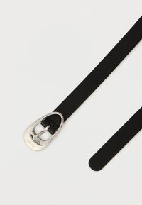 Μαύρη δερμάτινη ζώνη με επάργυρη μεταλλική πόρπη, με κομψό οβάλ σχήμα και λεία υφή. Διακοσμημένη με το όνομα της μάρκας "HUGO".