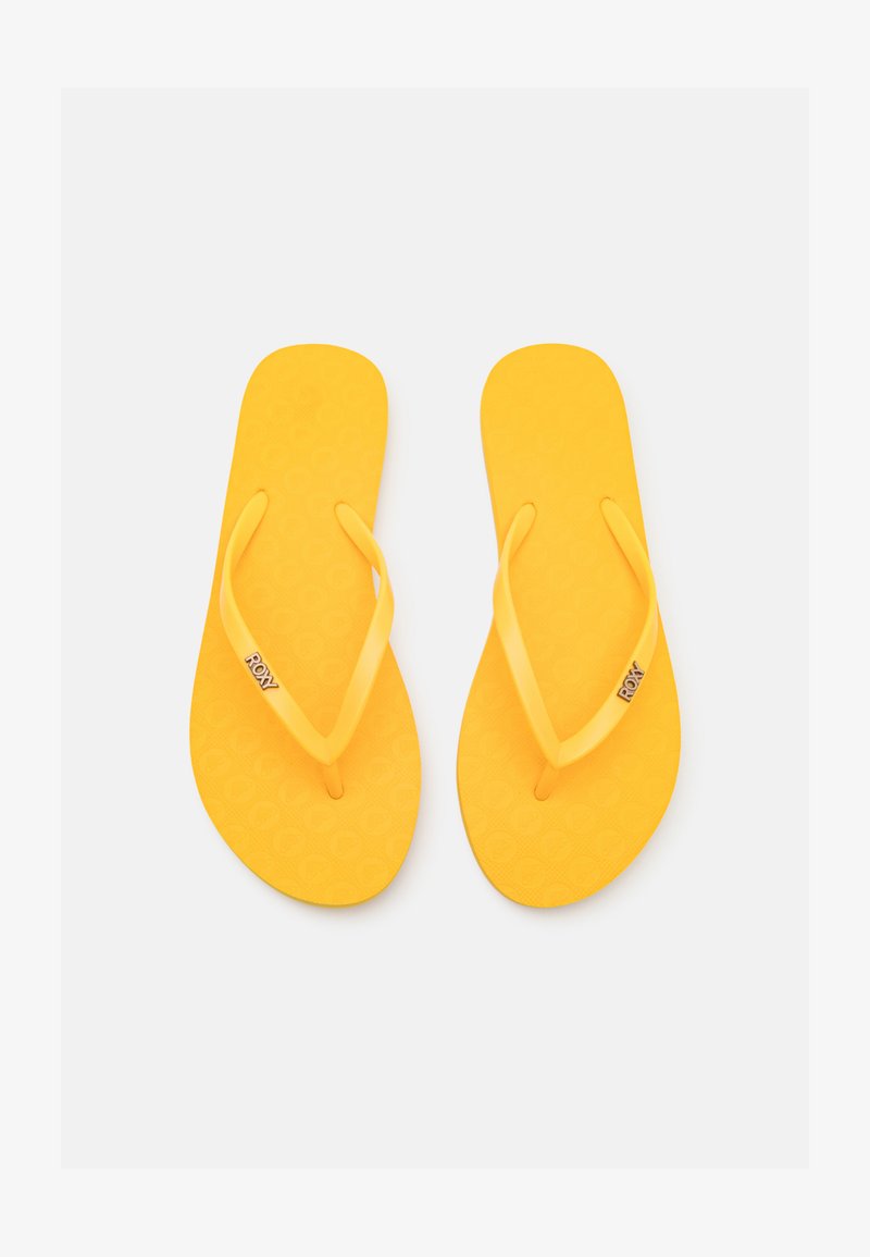 Yellow flip-flops made of rubber, featuring a textured footbed, thin straps, and a circular pattern. Logo displayed on one strap.