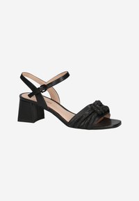Sandales à talons noires en cuir avec une bride croisée, présentant un détail noué à l'avant et un design texturé plissé sur le dessus.