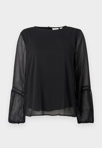 Blouse noire à manches longues avec manches transparentes, détail en dentelle près des poignets, col rond et fermeture par boutons au dos.