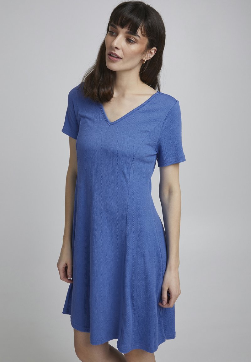 Blaue, strukturierte Kleid mit kurzen Ärmeln, einem V-Ausschnitt und einer ausgestellten Silhouette. Der Stoff wirkt leicht und lässig.