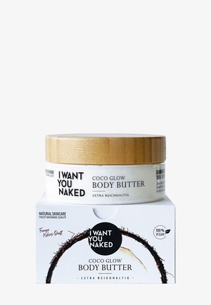 Cocosduftende „I Want You Naked“ Coco Glow Körperbutter im Glas mit Holzdeckel auf passender weißer Schachtel, gekennzeichnet als 100 % vegan und extra reichhaltig.