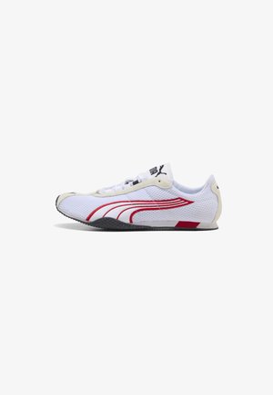 Hvid lav Puma sneaker med røde striber, sort sål og beige accenter set fra siden på hvid baggrund.