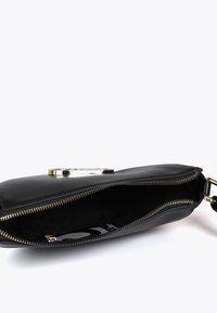 Svart kuvertväska med en gyllene dragkedja och rem, delvis öppen för att avslöja ett tomt inre och ett mönstrat tygfoder.