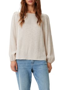 Helle beige Bluse mit langen Ärmeln aus strukturiertem Stoff, mit einem dezenten Schriftmuster, runden Ausschnitt und elastischen Bündchen.