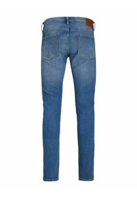 Jeans in denim blu con vestibilità slim, caratterizzati da una vita media, due tasche posteriori e una patch in pelle marrone sulla vita.