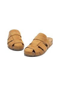 Sandali slip-on in suede marrone con design open-toe, caratterizzati da cinturini incrociati e un sottopiede in sughero testurizzato per il comfort.