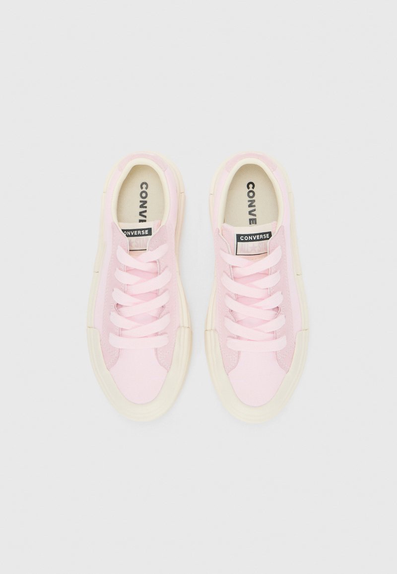 Helle rosa Leinenschuhe mit weißen Schnürsenkeln, verstärkter Zehenpartie und cremefarbener Gummisohle. Mit schwarzem "CONVERSE ALL STAR"-Etikett auf der Zunge.