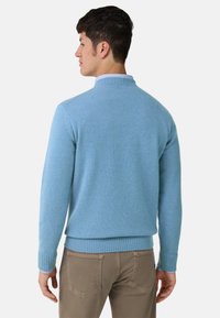 Světlomodrý svetr s žebrovaným límcem a manžetami, vyrobený z měkkého pleteného materiálu, s přiléhavým střihem a hladkou texturou.