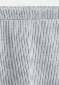 Tissu en maille côtelée gris clair avec des lignes verticales et un large détail de ceinture élastique en haut.