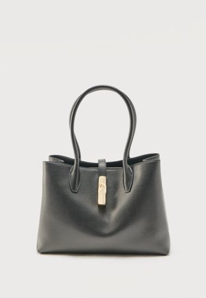 Sac à main en cuir noir avec deux poignées et un fermoir doré sur une sangle supérieure, posé sur un fond clair uni.