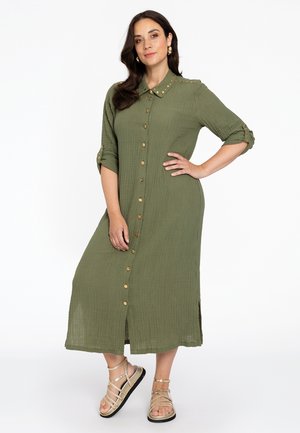 Olijfgroen button-up jurk in een textuurstof, met een kraag, oprolbare mouwen en gouden knoopaccenten.
