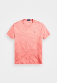 Koralowa koszulka z krótkim rękawem z bawełny, z okrągłym dekoltem i małym haftowanym logo na lewej piersi. Miękka, gładka faktura.