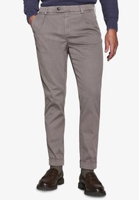 Lys grå chinos lavet af struktureret stof. Har en slim fit, sidelommer og opfoldede manchetter. Paireret med mørkebrune loafers.