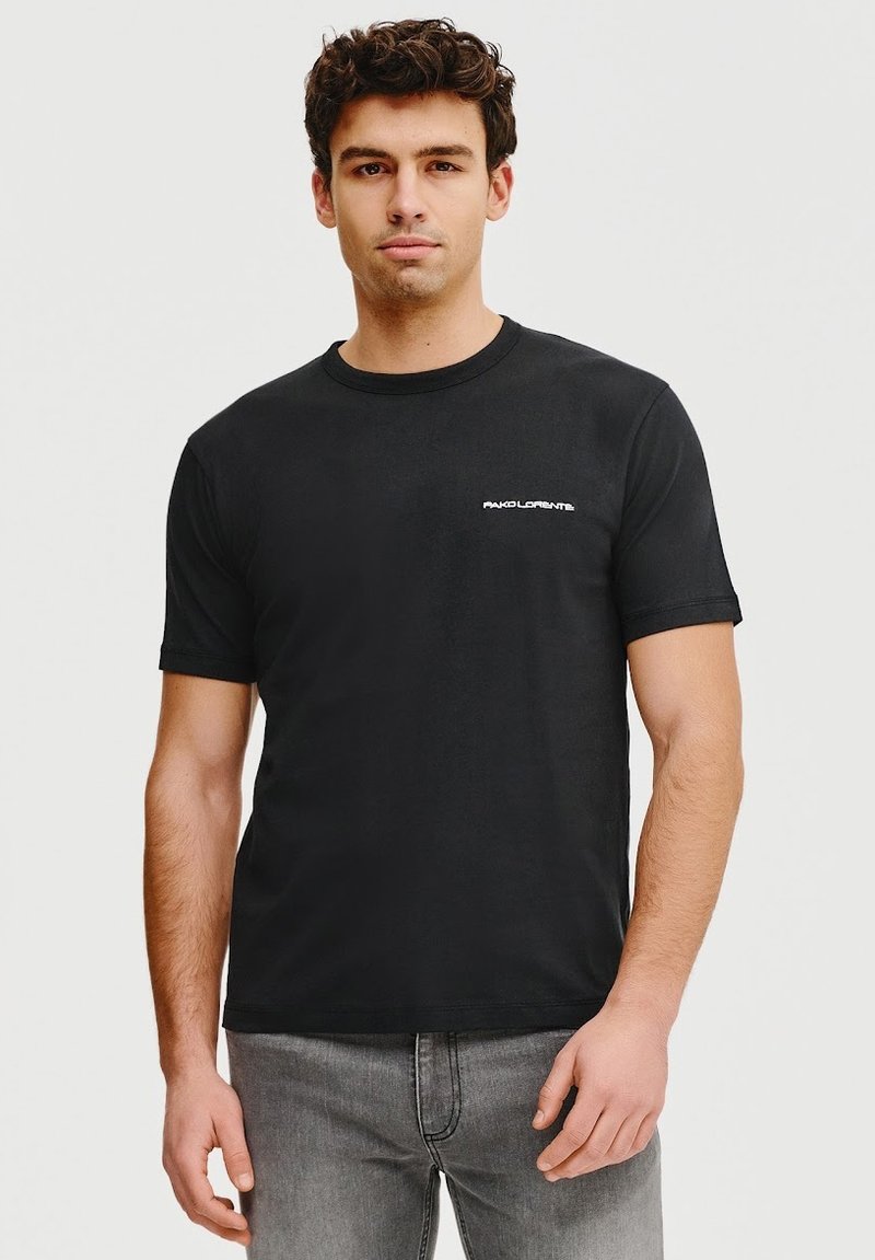 Czarna bawełniana koszulka z okrągłym dekoltem i krótkimi rękawami, z małym białym logo na lewej stronie klatki piersiowej.