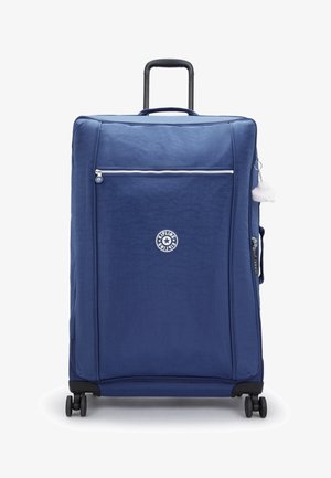 Maleta azul de carcasa blanda con un bolsillo frontal con cremallera, ruedas negras, asa retráctil y una etiqueta de accesorio blanca y esponjosa adjunta.