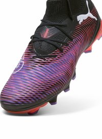Crampons de football noirs et violets avec une surface texturée, un motif de rayures dynamiques et un col en chaussette noir. Comprend des accents roses et des crampons moulés.