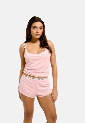 Pink ribbed tank top with adjustable straps, paired with matching shorts featuring a branded elastic waistband. Smooth texture and fitted design.