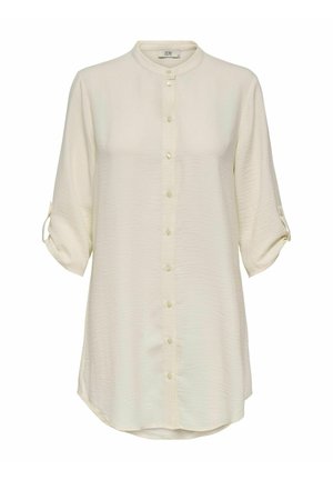 Light beige long-sleeve shirt with a mandarin collar, front buttons, and rolled cuffs. Made of soft, textured fabric with a rounded hem.