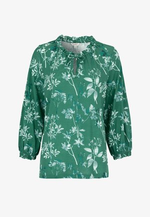 Grøn bluse med lange ærmer med hvide og blå blomsterprint, elastiske manchetter og en flæsekrave med en bindedetalje foran.
