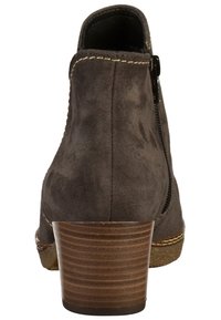 Bottine en daim gris avec un bout arrondi, une fermeture éclair latérale et un talon empilé présentant des rainures horizontales pour une meilleure adhérence.