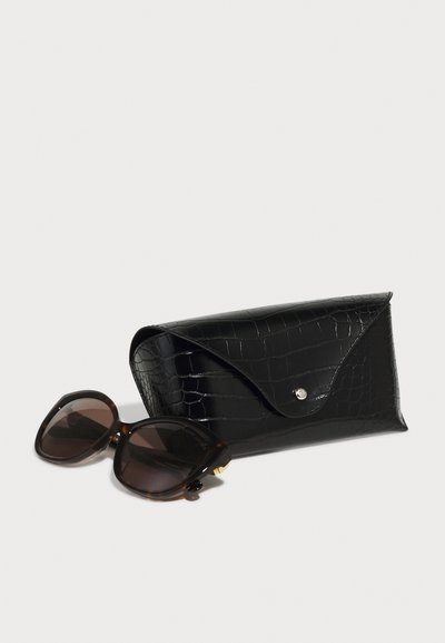 Black croc-embossed sunglasses case with a snap closure next to large, dark brown, tortoiseshell sunglasses with rounded frames.