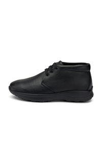 Scarpa alla caviglia in pelle nera con allacciatura frontale, collo imbottito e suola in gomma texturizzata, mostrata in profilo laterale su sfondo bianco.