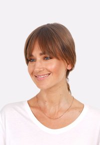 Tricou alb cu mânecă scurtă, lănțișor delicat din aur roz cu mărgele mici, detalii texturale moi, purtat de o femeie cu păr de lungime medie.