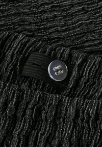 Tissu noir texturé avec un motif ondulé, comprenant un bouton transparent et une sangle noire. La texture semble douce et superposée.