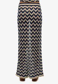 Maxikjole med et zigzag-mønster i marineblå og beige, lavet af et gennemsigtigt, struktureret stof med en subtil glans. Nederkanten er let udstyret.