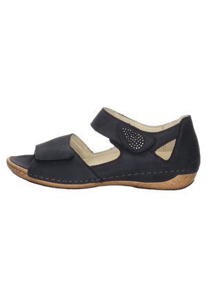 Black leather sandal with open toe, adjustable Velcro strap, perforated accent, tan cork sole, and stitched detailing along the edges.