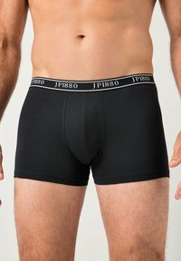 Bóxers de algodón negro de ajuste ajustado, con una cintura que lleva la etiqueta "JP1880" en blanco. Textura suave sin patrones visibles.