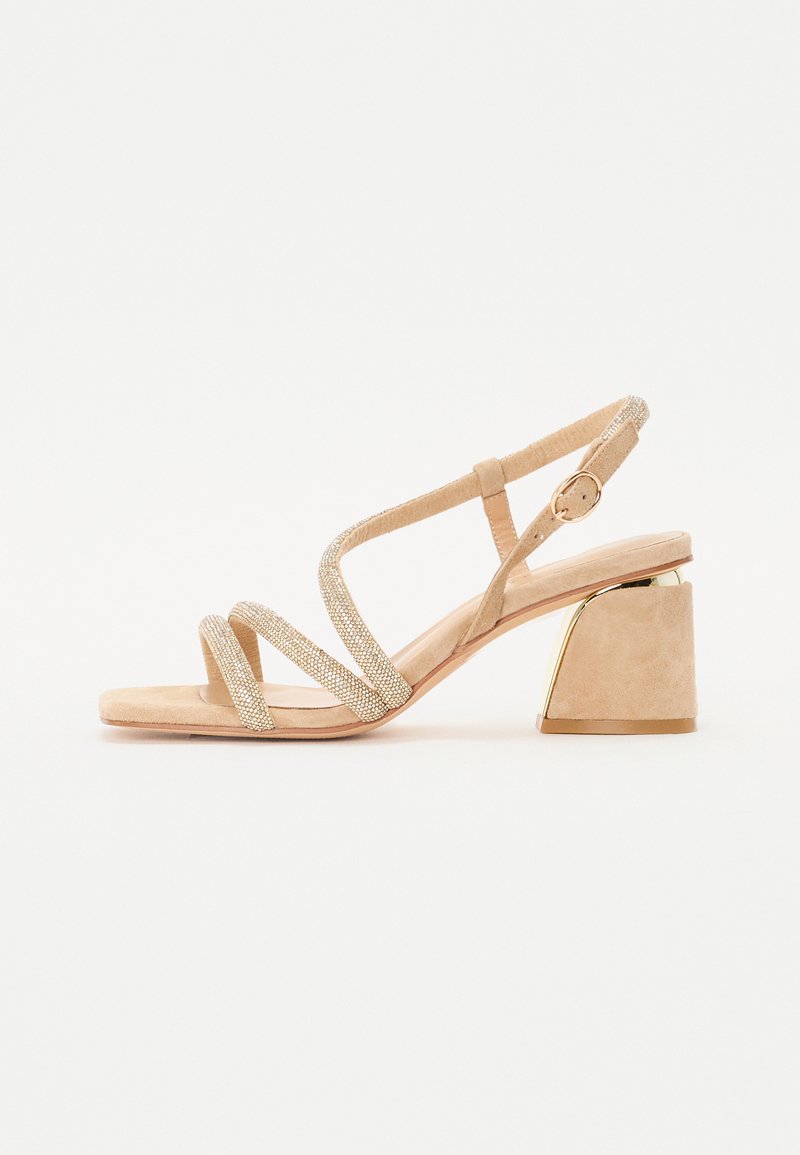 Sandales à talons nus avec finition en suède, brides scintillantes, design à bout ouvert et un talon bloc structuré accentué de doré.