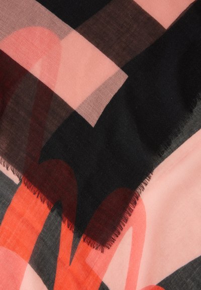 Couches de tissu superposées dans des tons doux noir, rose, marron et orange avec des formes géométriques et des bords frangés.