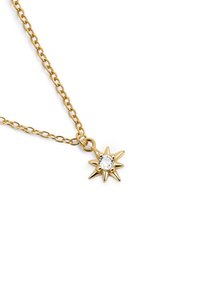 Collana d'oro con pendente a forma di stella, con una pietra preziosa trasparente al centro. La catena è composta da fini anelli intrecciati.